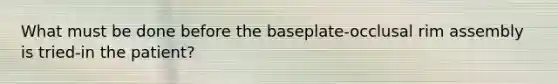 What must be done before the baseplate-occlusal rim assembly is tried-in the patient?