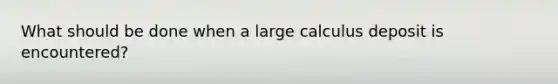 What should be done when a large calculus deposit is encountered?