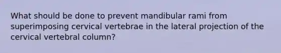 What should be done to prevent mandibular rami from superimposing cervical vertebrae in the lateral projection of the cervical vertebral column?