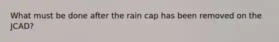 What must be done after the rain cap has been removed on the JCAD?