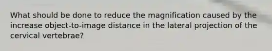 What should be done to reduce the magnification caused by the increase object-to-image distance in the lateral projection of the cervical vertebrae?