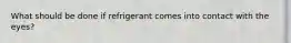 What should be done if refrigerant comes into contact with the eyes?