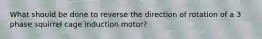 What should be done to reverse the direction of rotation of a 3 phase squirrel cage induction motor?