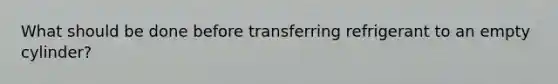 What should be done before transferring refrigerant to an empty cylinder?