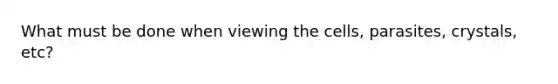 What must be done when viewing the cells, parasites, crystals, etc?
