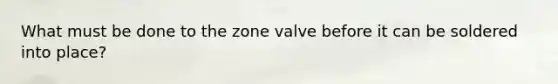 What must be done to the zone valve before it can be soldered into place?