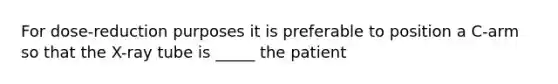 For dose-reduction purposes it is preferable to position a C-arm so that the X-ray tube is _____ the patient