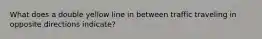 What does a double yellow line in between traffic traveling in opposite directions indicate?