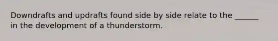 Downdrafts and updrafts found side by side relate to the ______ in the development of a thunderstorm.