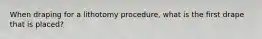 When draping for a lithotomy procedure, what is the first drape that is placed?