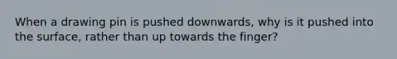 When a drawing pin is pushed downwards, why is it pushed into the surface, rather than up towards the finger?