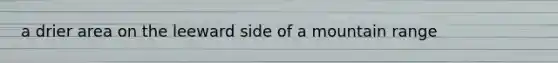 a drier area on the leeward side of a mountain range