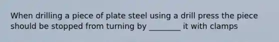 When drilling a piece of plate steel using a drill press the piece should be stopped from turning by ________ it with clamps