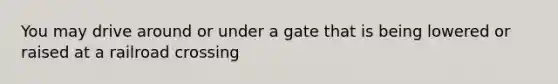 You may drive around or under a gate that is being lowered or raised at a railroad crossing