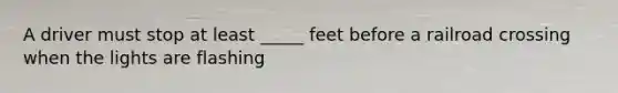 A driver must stop at least _____ feet before a railroad crossing when the lights are flashing