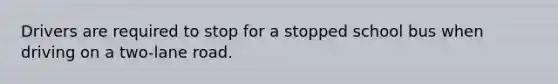 Drivers are required to stop for a stopped school bus when driving on a two-lane road.