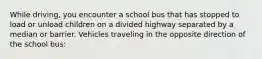 While driving, you encounter a school bus that has stopped to load or unload children on a divided highway separated by a median or barrier. Vehicles traveling in the opposite direction of the school bus: