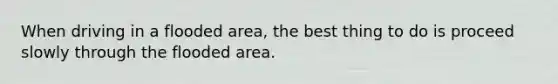 When driving in a flooded area, the best thing to do is proceed slowly through the flooded area.