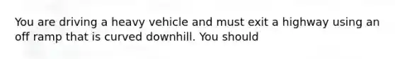 You are driving a heavy vehicle and must exit a highway using an off ramp that is curved downhill. You should