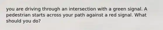 you are driving through an intersection with a green signal. A pedestrian starts across your path against a red signal. What should you do?