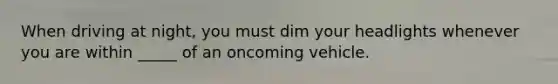 When driving at night, you must dim your headlights whenever you are within _____ of an oncoming vehicle.