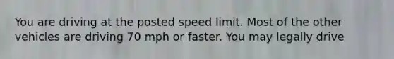 You are driving at the posted speed limit. Most of the other vehicles are driving 70 mph or faster. You may legally drive