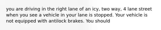 you are driving in the right lane of an icy, two way, 4 lane street when you see a vehicle in your lane is stopped. Your vehicle is not equipped with antilock brakes. You should