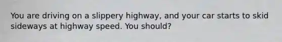 You are driving on a slippery highway, and your car starts to skid sideways at highway speed. You should?