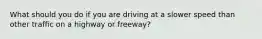 What should you do if you are driving at a slower speed than other traffic on a highway or freeway?