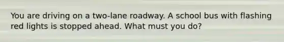You are driving on a two-lane roadway. A school bus with flashing red lights is stopped ahead. What must you do?