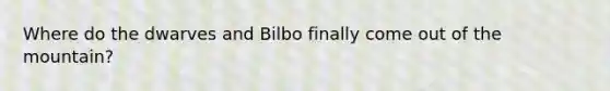 Where do the dwarves and Bilbo finally come out of the mountain?