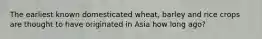 The earliest known domesticated wheat, barley and rice crops are thought to have originated in Asia how long ago?