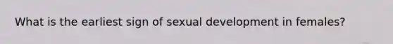 What is the earliest sign of sexual development in females?