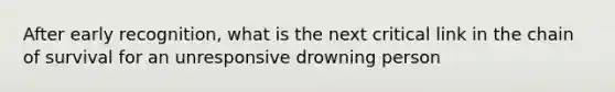 After early recognition, what is the next critical link in the chain of survival for an unresponsive drowning person