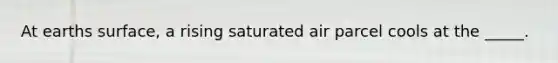 At earths surface, a rising saturated air parcel cools at the _____.