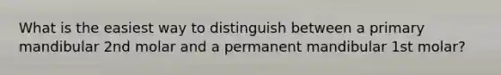 What is the easiest way to distinguish between a primary mandibular 2nd molar and a permanent mandibular 1st molar?