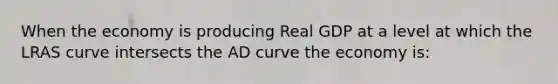 When the economy is producing Real GDP at a level at which the LRAS curve intersects the AD curve the economy is: