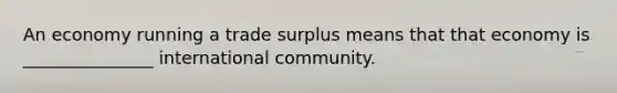 An economy running a trade surplus means that that economy is _______________ international community.