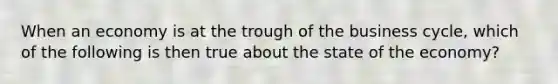 When an economy is at the trough of the business cycle, which of the following is then true about the state of the economy?