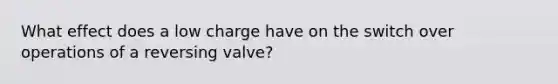 What effect does a low charge have on the switch over operations of a reversing valve?