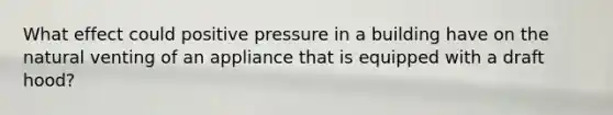 What effect could positive pressure in a building have on the natural venting of an appliance that is equipped with a draft hood?