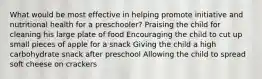 What would be most effective in helping promote initiative and nutritional health for a preschooler? Praising the child for cleaning his large plate of food Encouraging the child to cut up small pieces of apple for a snack Giving the child a high carbohydrate snack after preschool Allowing the child to spread soft cheese on crackers