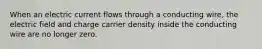 When an electric current flows through a conducting wire, the electric field and charge carrier density inside the conducting wire are no longer zero.