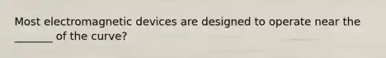 Most electromagnetic devices are designed to operate near the _______ of the curve?
