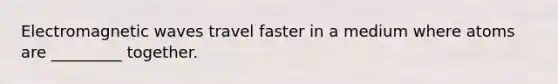 Electromagnetic waves travel faster in a medium where atoms are _________ together.