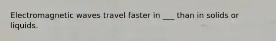 Electromagnetic waves travel faster in ___ than in solids or liquids.