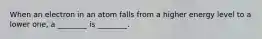 When an electron in an atom falls from a higher energy level to a lower one, a ________ is ________.