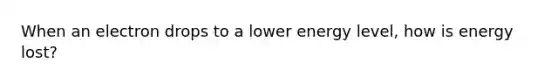 When an electron drops to a lower energy level, how is energy lost?