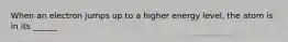 When an electron jumps up to a higher energy level, the atom is in its ______