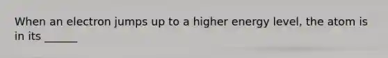 When an electron jumps up to a higher energy level, the atom is in its ______